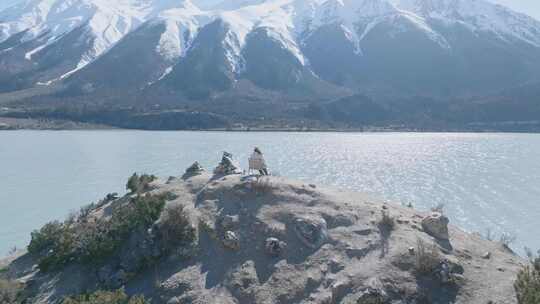 航拍女人坐在西藏昌都然乌湖畔