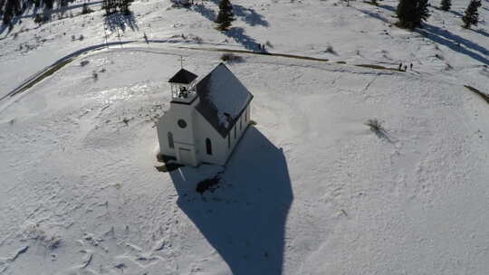 雪山田野上的教堂天线，向后拉以显示景观