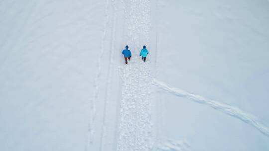 航拍人在雪地中行走
