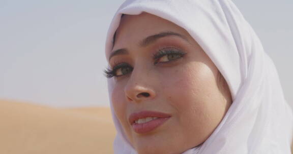 穆斯林妇女站在多风的沙漠中