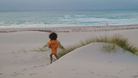 女人漫步海滩暮光之城与橙色花朵