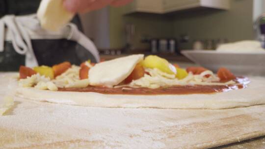 特写把马苏里拉奶酪放在比萨面团上视频素材模板下载