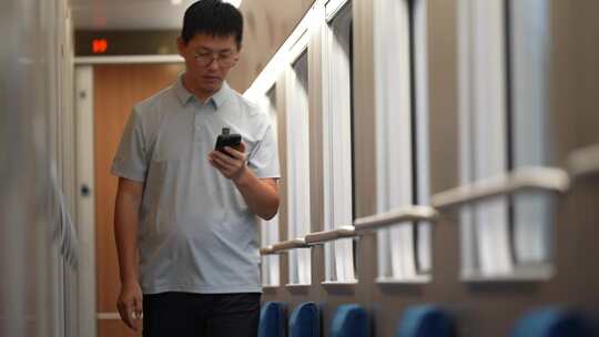 男子在卧铺火车过道上使用手机