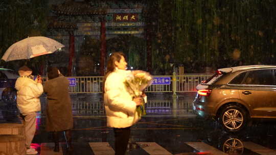 大明湖夜晚下雪 马路边拿花的女子