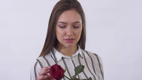 女人从红玫瑰上摘下花瓣