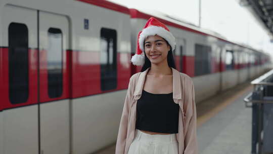 刚下火车的快乐女人的肖像在旅行中庆祝圣诞