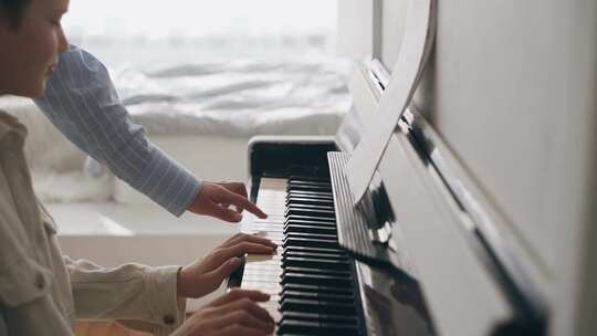 老师指导孩子学习弹钢琴