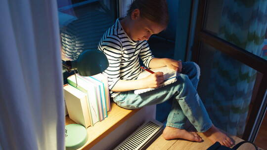 夜晚女孩坐在书桌上写作业