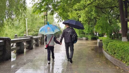 雨天父亲送儿子上学背影