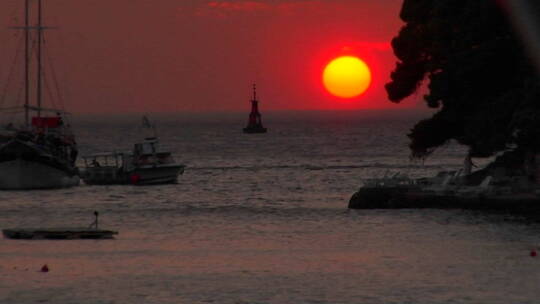 红色的克罗地亚太阳正坐在水面上