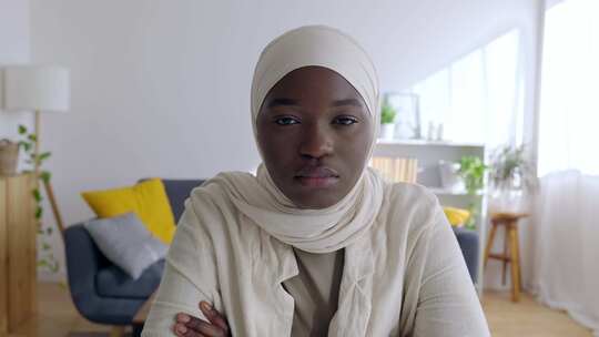 戴着白色穆斯林头巾的非洲妇女在家看着相机