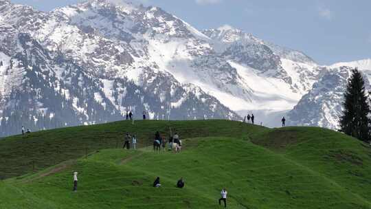 恰西雪山下，草地上打卡拍照骑马路过游客