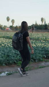 内容创作者女性在农村散步，为社交媒体拍摄