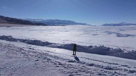 女孩在新疆赛里木湖白雪覆盖的湖面上行走