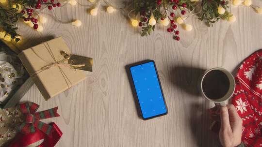 桌子上的圣诞物品和蓝屏手机视频素材模板下载