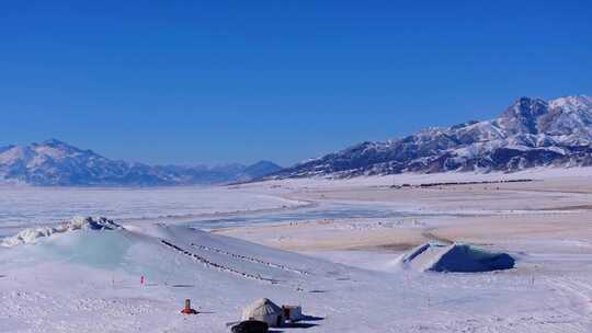 航拍新疆冬季赛里木湖冰封湖面雪山冰湖积雪