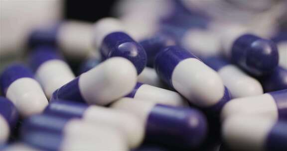 紫色和白色的药胶囊躺在一堆