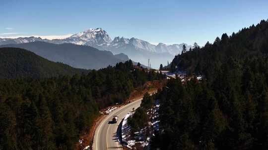 航拍雪山森林公路车辆行驶