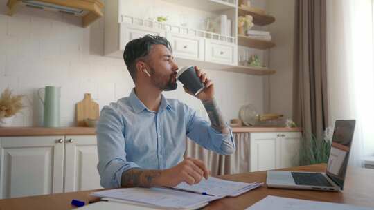 英俊的男人在工作中喝咖啡体贴的商人在笔记