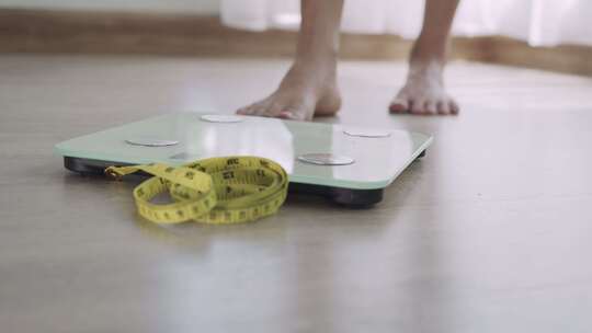 减肥的女性正在称体重视频素材模板下载