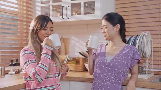 亚洲美女朋友在厨房一起喝一杯咖啡。