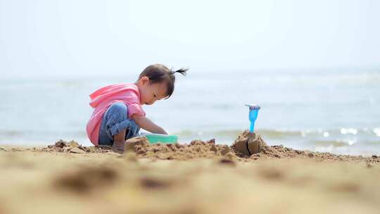 小孩在海边玩沙子