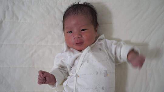 床上平躺的新生儿