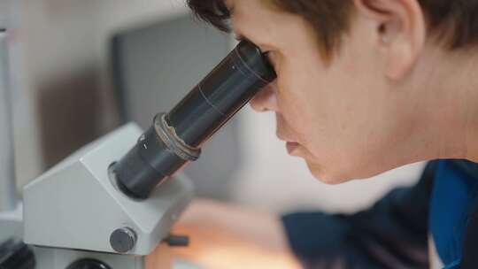 科学家在实验室环境中用显微镜检查样品
