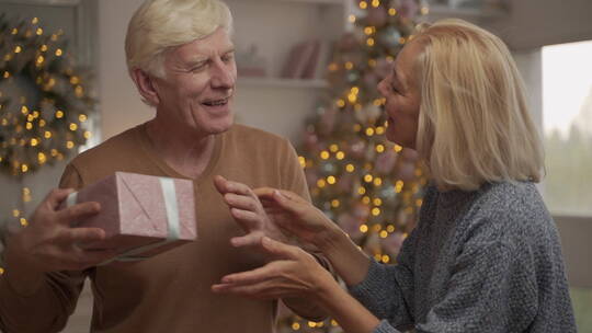 老妇人给丈夫送圣诞礼物视频素材模板下载