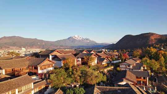 云南丽江古城屋顶和玉龙雪山日出清晨航拍