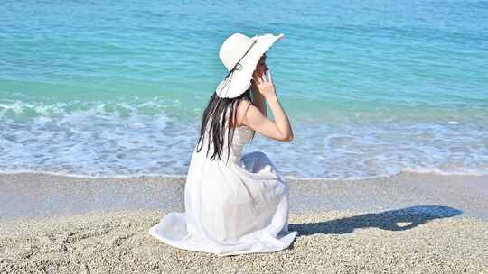 海南三亚漂亮女孩在沙滩拍摄蔚蓝色海洋背影