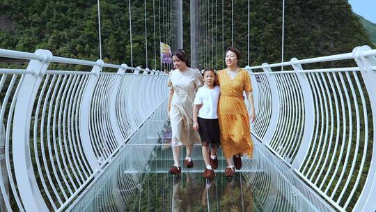 4K升格实拍走在景区玻璃栈道吊桥上母女三人