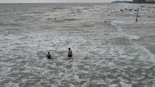 航拍海边人群在海中嬉戏的热闹场景