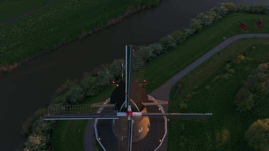 荷兰黄昏时风车、河流、小径和树木的鸟瞰图