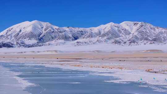 航拍新疆冬季赛里木湖冰封湖面雪山冰湖积雪