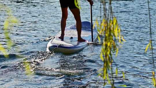 人在水面划桨板的场景
