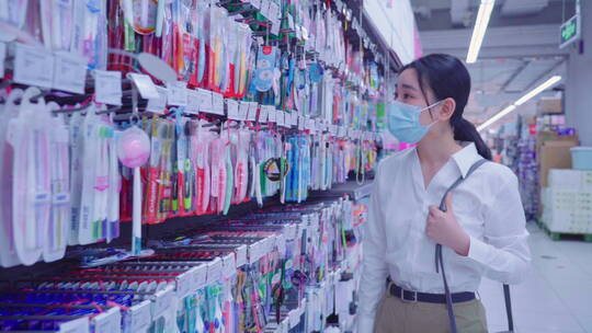戴口罩的青年女人在超市购物