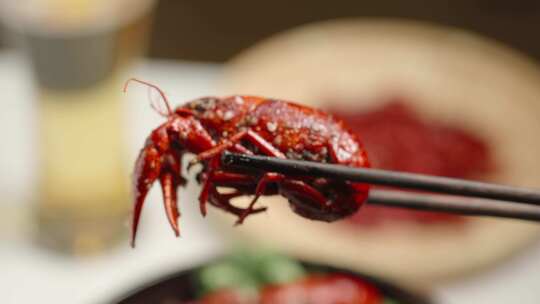 筷子夹起小龙虾夜宵美食特写