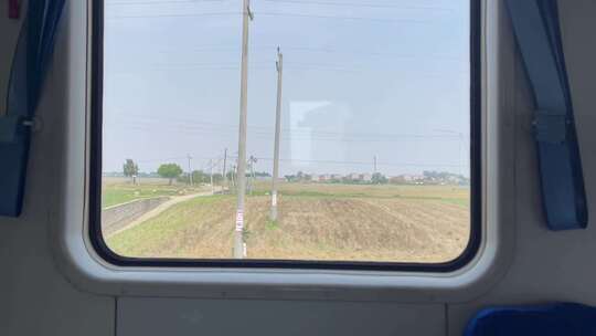 行驶中的火车窗外的村庄庄稼风景