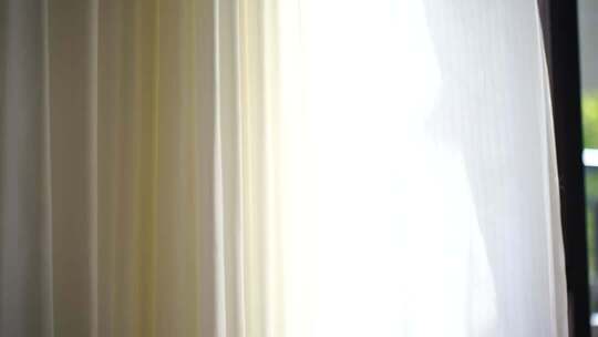风吹窗帘窗户白色窗帘飘动阳光透过白色窗帘
