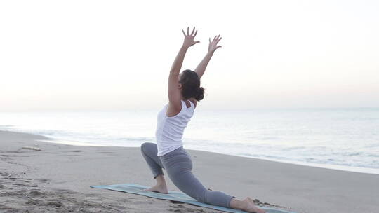 年轻女子在海边做瑜伽