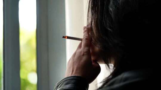 男子窗边抽烟特写素材