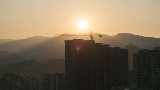 城市摩天大楼建筑工地塔式起重机上的日出。延时