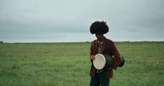 一个年轻人在草地上演奏Djembe