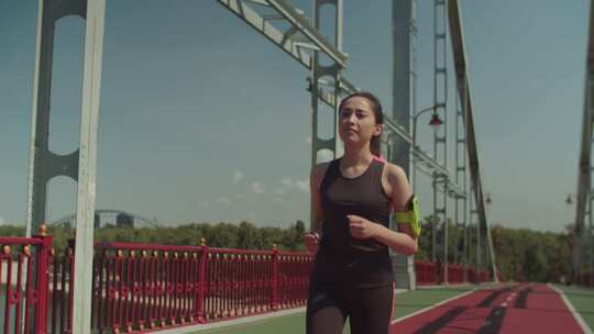 亚洲女慢跑者在人行桥上跑步视频素材模板下载