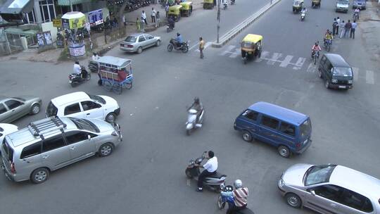 车辆和行人穿过繁忙的十字路口视频素材模板下载