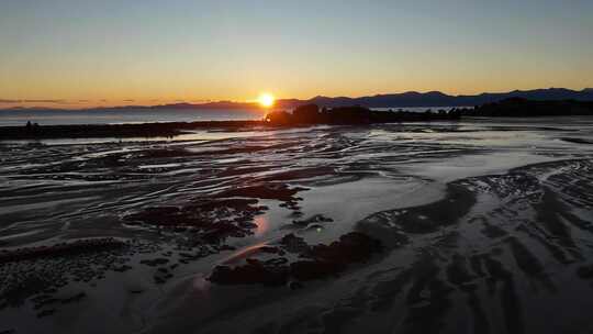 太阳落在海洋和沙滩上