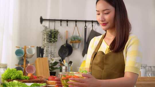 亚洲年轻女子早上在家厨房烹饪健康食品