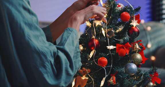 一个漂亮的女人正在家里为圣诞晚会装饰一棵松树。