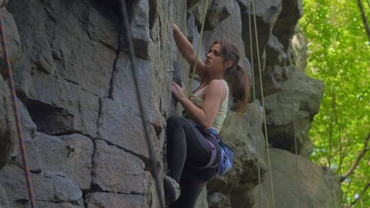 女人攀登山上的岩石